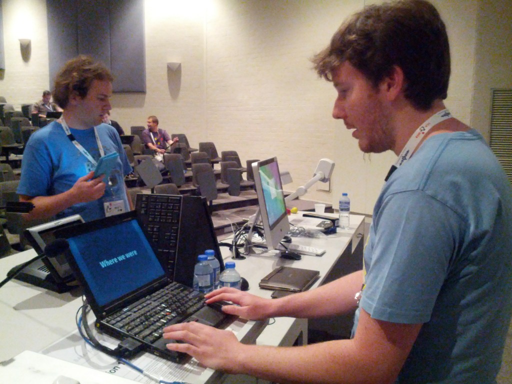 Lending my VGA enabled Thinkpad to @lgnome whist a @chrisjrn observes. 